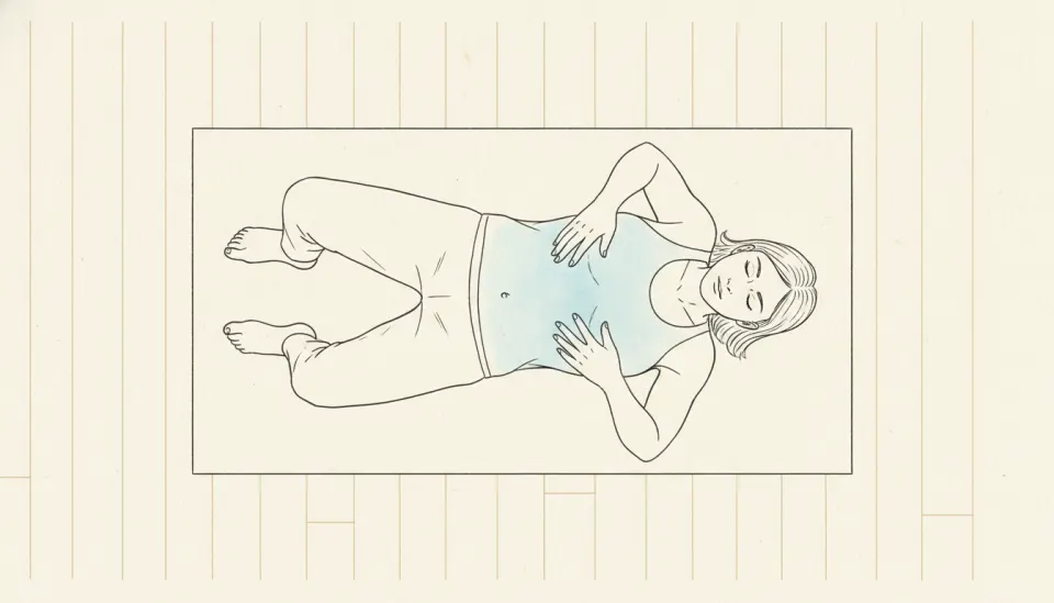 A person lies on a mat, knees bent, one hand resting on the lower ribs, noticing the breath